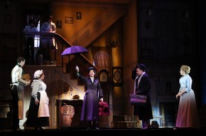 Stefanie Jones as Mary Poppins holds up an umbrella alongside others from the cast on a stage during a media preview of Mary Poppins.
