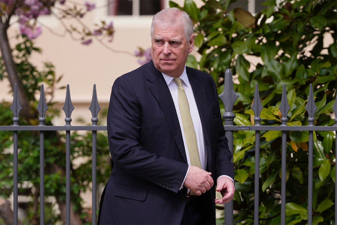Prince Andrew, the Duke of York, looking over his shoulder while wearing a suit.