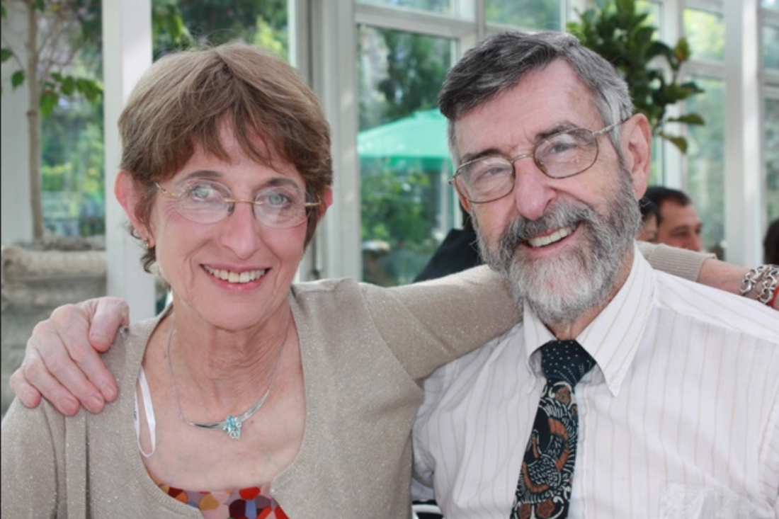 Phyllis Strauss and her husband Walter Strauss shown smiling with their arms around each other at an indoor event.