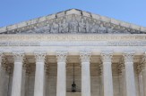 The exterior of the Supreme Court building set against a blue sky.