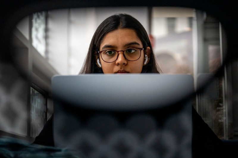 A student works on a laptop.