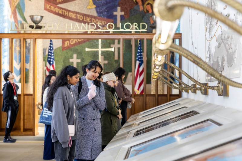 Two women look down at screens in a museum.
