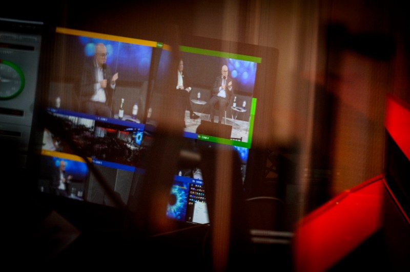 A screen displaying President Aoun and Howard Purcell in conversation. 