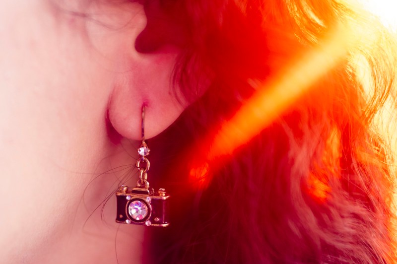 A close-up of Samantha Davidson's earring, which has a camera jewel hanging from it. 