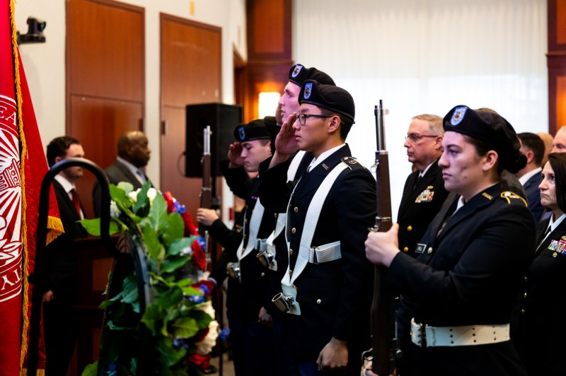 Students dressed in military uniforms and berets stand at attention indoors at the 2025 Veterans Day Ceremony.