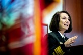 Rear Admiral Jennifer S. Couture in navy uniform gesturing while speaking at the 2025 Veterans Day Ceremony.