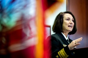 Rear Admiral Jennifer S. Couture in navy uniform gesturing while speaking at the 2025 Veterans Day Ceremony.