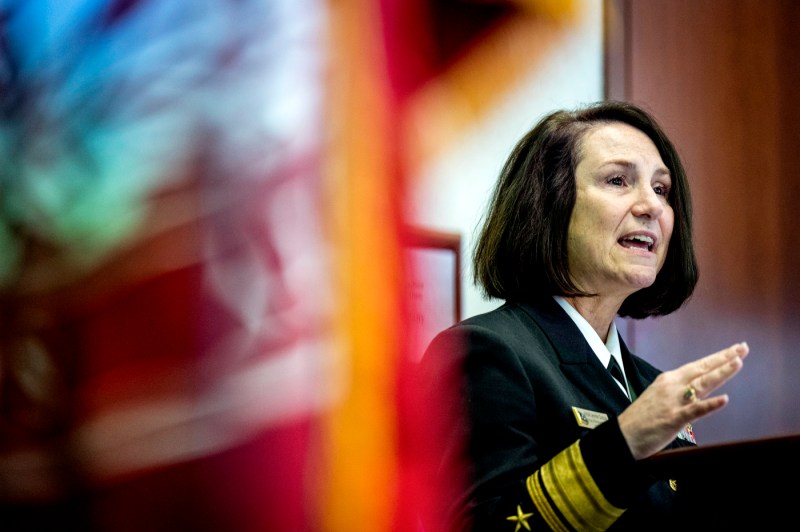Rear Admiral Jennifer S. Couture in navy uniform gesturing while speaking at the 2025 Veterans Day Ceremony.