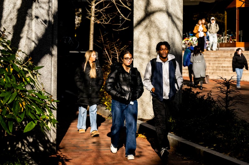 Students, dressed in jackets for colder weather, walk through the Boston campus. 