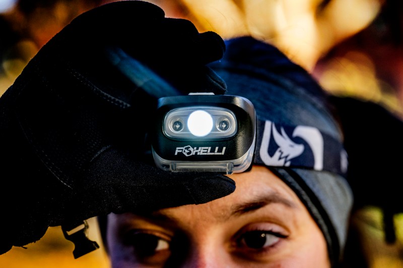 Close-up photo of a person adjusting their headlamp on their head.
