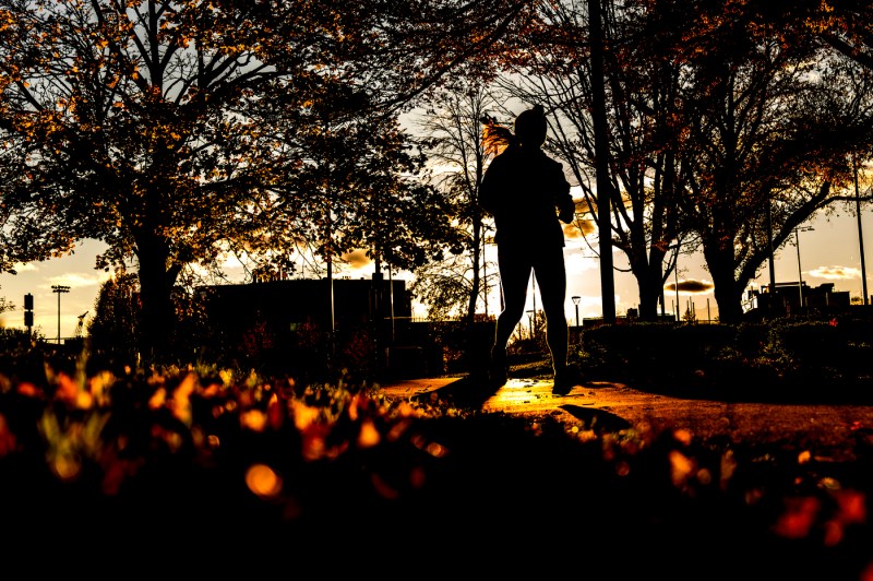 A silhouette of a person running down a path.