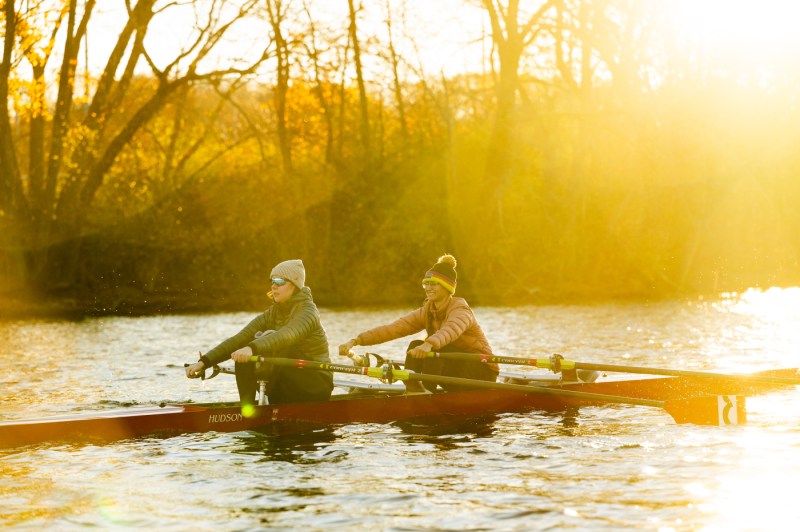 Two people row in a double skull at golden hour.