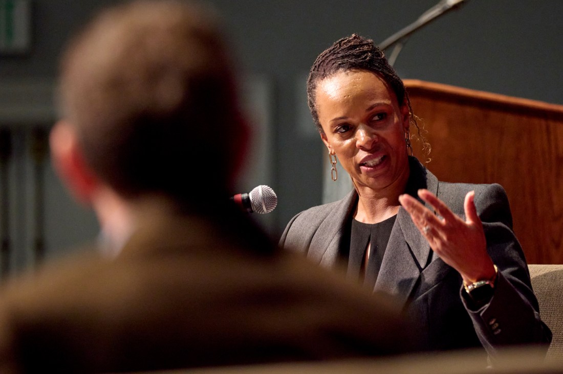 A speaker gestures while addressing someone in the audience during a Q&A session at a Northeastern University event.