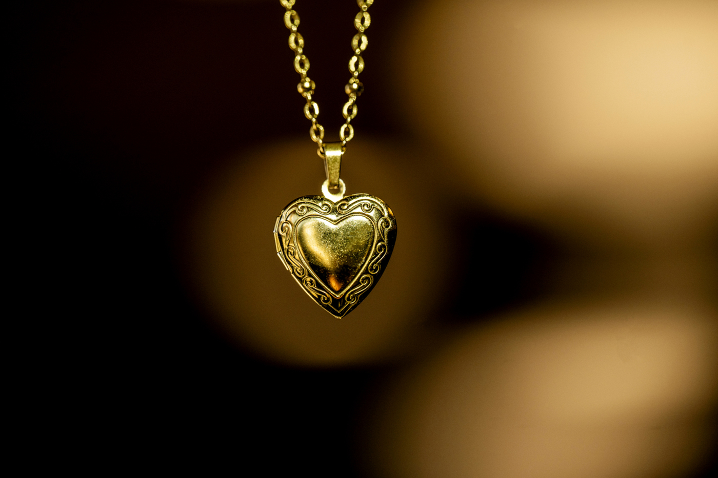 A close-up of a gold necklace with a heart.