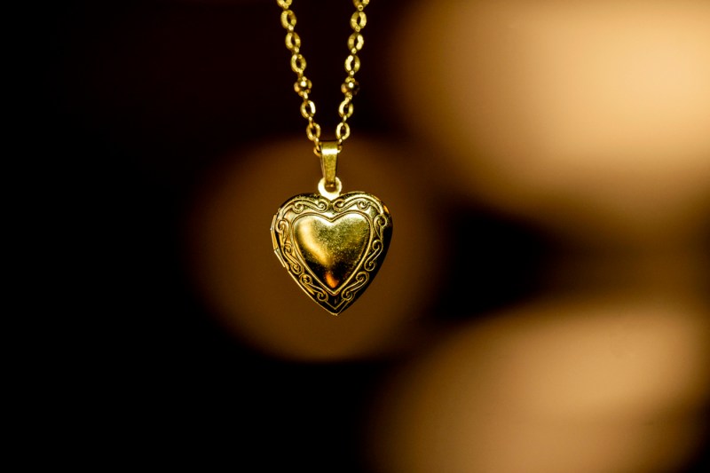 A gold-tone heart-shaped locket hangs on a gold-tone chain.