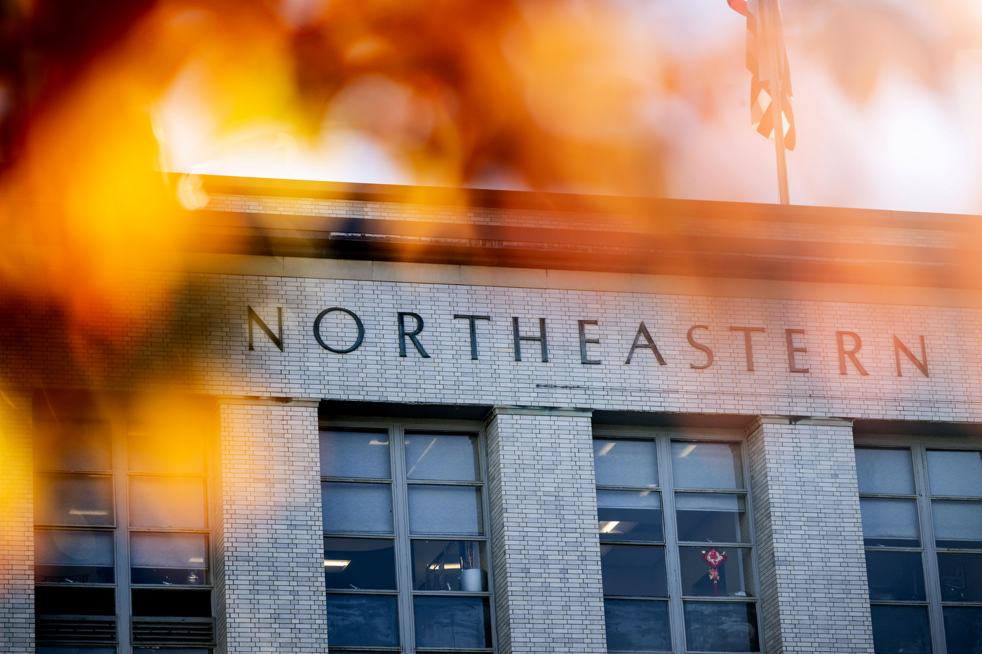 With a red, orange and yellow blur on the left side, Ell Hall is photographed. 