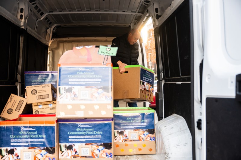 A van is packed with cardboard boxes for a food drive.