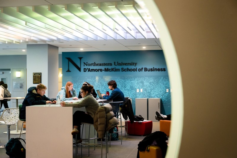 Students sit at a table in the D'Amore-McKim School of Business.