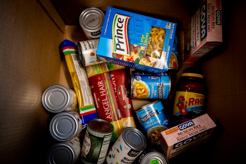 A box full of food, including Prince pasta, Goya products, and cans.