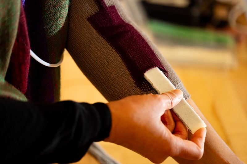 A person puts on an adaptive splint on their arm.