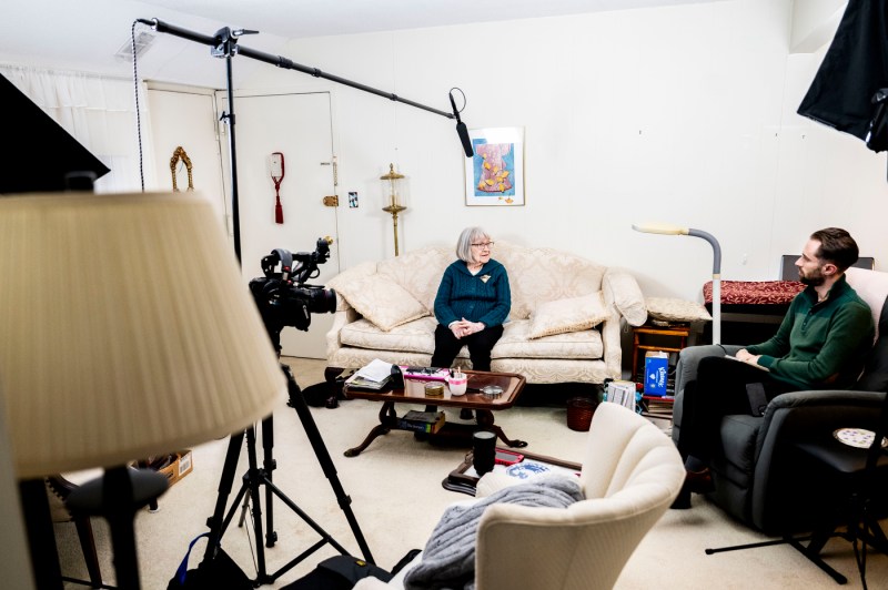 Ruth Gove sits on a sofa in her room as she speaks with a journalist.