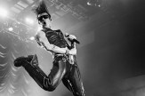 British rocker Yungblud, donned in black leather, leaping in the air during a concert.
