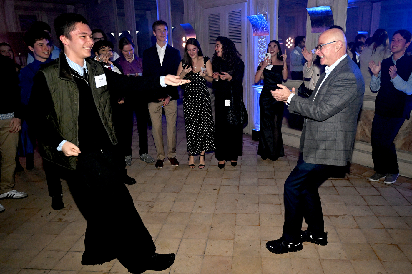 A number of people dance with a suited Northeastern University president Joseph Aoun