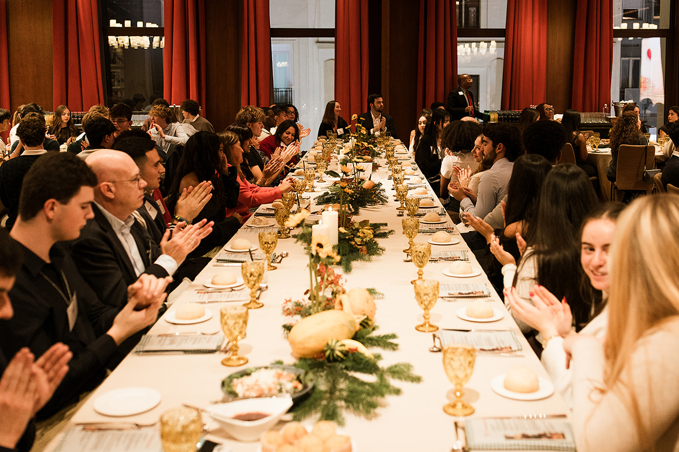 People applaud while sitting at a banqueting table