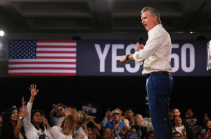 Gov. Gavin Newsom speaks during a campaign event on Proposition 50, which is displayed next to an American flag in the background.