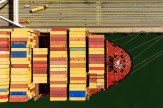 Cargo containers of yellow, blue, green and red colors line a ship at the Port of Oakland.