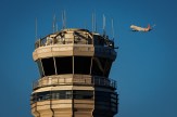 An American Eagle flight takes off in a cloudless sky behind an Air Traffic Control Tower at the Ronald Reagan.
