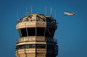 An American Eagle flight takes off in a cloudless sky behind an Air Traffic Control Tower at the Ronald Reagan.