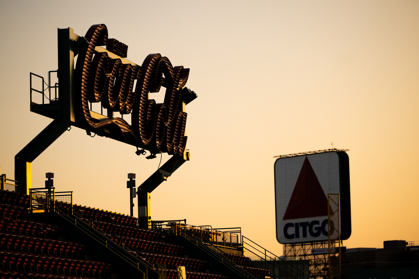 Silhouette of the iconic Boston industrial Citgo sign and the Coca Cola light up-logo sign outside of Fenway Park. 