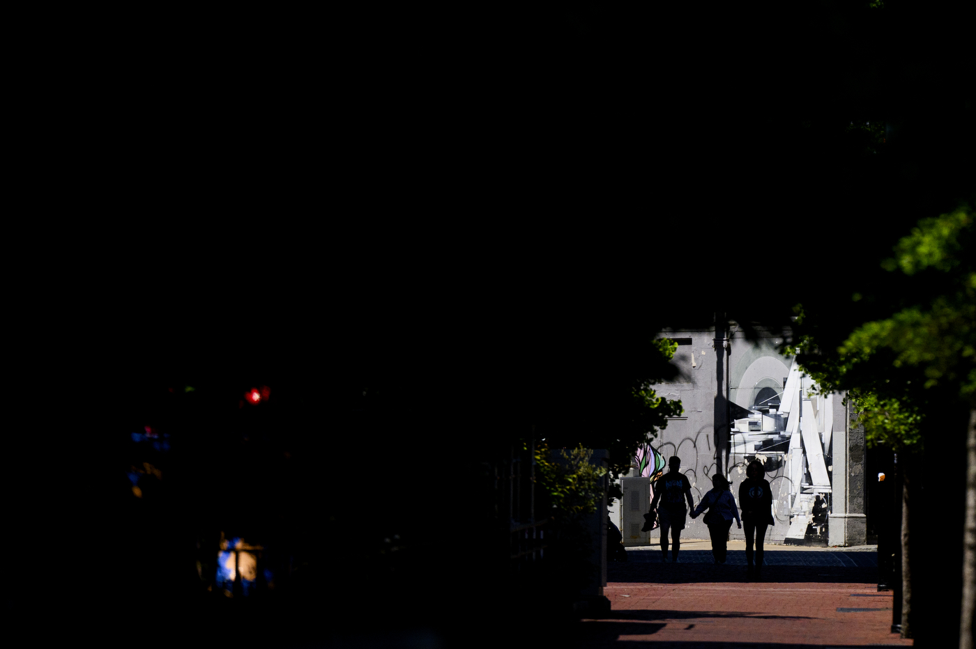 Silhouettes of students walking through campus. 