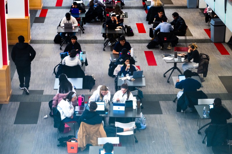 Students sit at tables as they work on assignments in the Curry Student Center.