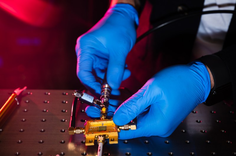 Closeup of professor's hands working delicately on tiny sensor technology.
