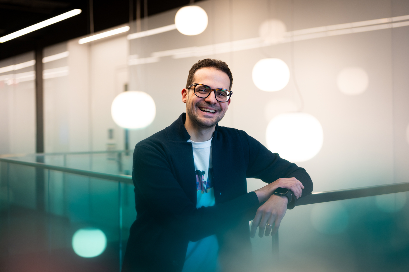 Subject smiles for a portrait while leaning on railing.