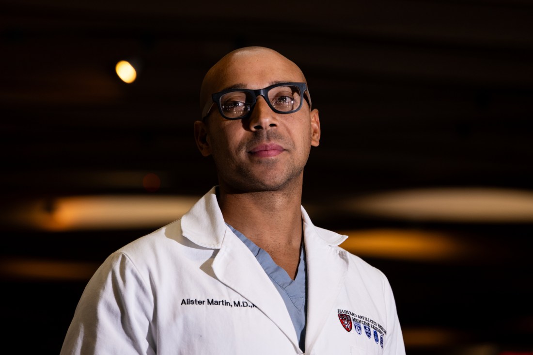 Dr. Alister Martin, emergency physician and founder of A Healthier Democracy, wearing a white medical coat and glasses in portrait at Massachusetts General Hospital.