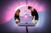 Two people look inside of an MRI machine.
