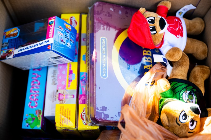 A close up of a box of board games, stuffed animals and toys.