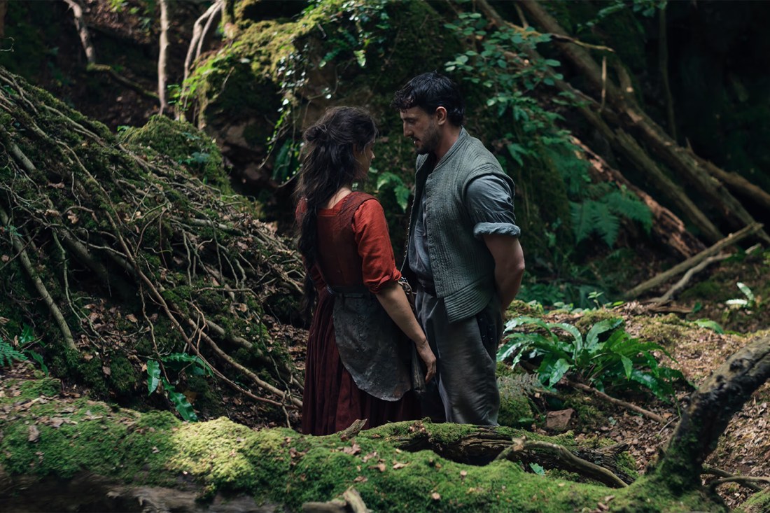 A male and female actor stare at each other in a forest setting