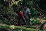 A male and female actor stare at each other in a forest setting