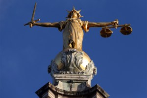 A gilt bronze statue of Lady Justice, sculpted by F.W. Pomeroy, on top of the Central Criminal Court building. Lady Justice is holding a sword in her right hand and scales in her left.