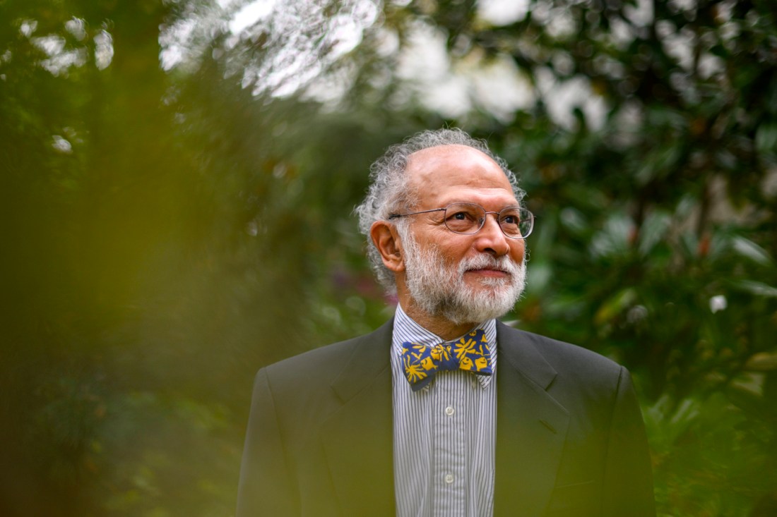 Portrait of Ravi Sarathy wearing a striped button down, a black blazer, and a blue bowtie with yellow geometric patterns on it.