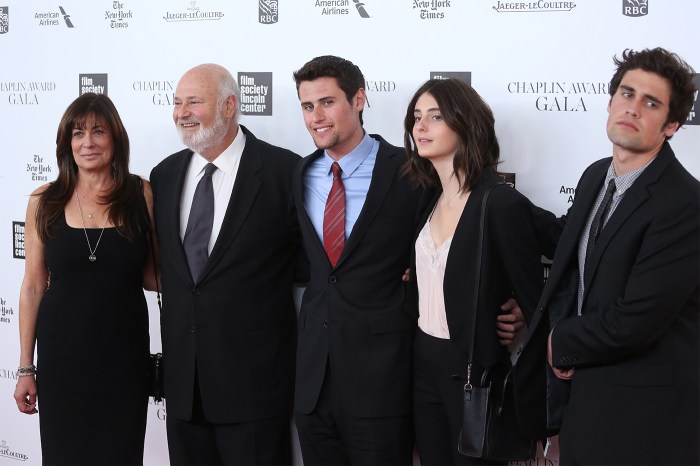 The Reiner family stand in black suits and dresses at an award gala. The five of them have their arms around each other.