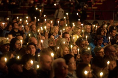A sea of faces, with candles held aloft, during a vigil.