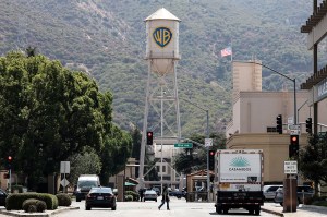 The Warner Brothers logo displayed on a water tower overlooking a street.