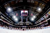 A wide-angled shot of a hockey stadium with the players lined up before the game.
