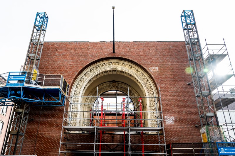 A low angle photo of the front of the Matthews Arena arch, with scaffolding on the outside of the building.