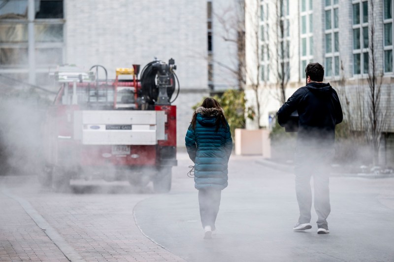 Two students walk between buildings on the Boston campus.